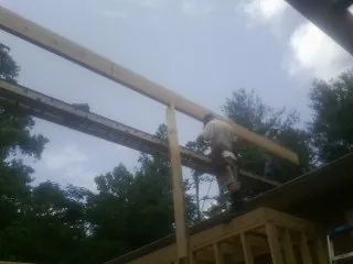 Carpenter setting a ridge beam over a new addition frame — Ice Dam Removal by Roofing Brothers in Lagro