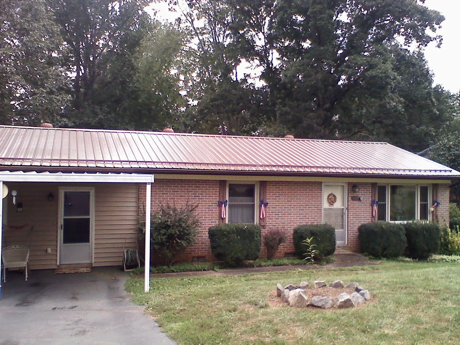 Bronze metal roof and carport on a brick ranch home — Roof Repair work by our crew in Lagro